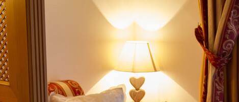 Una habitación acogedora con una cama de madera, una mesita de noche con lámpara y una alfombra estampada.