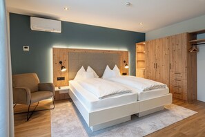 Junior-Suite mit Balkon, Seeblick | Ylelliset vuodevaatteet, tallelokero huoneessa