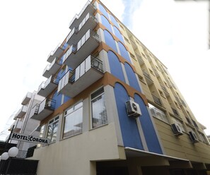 Un hôtel à plusieurs étages, doté de balcons et de climatiseurs.