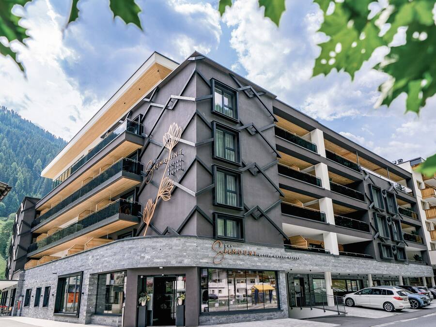 A multi-story hotel with a modern architectural design, featuring balconies and large windows.