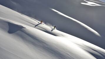 A snowy landscape with two skiers.