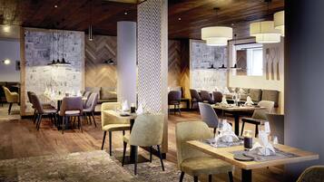 Un restaurant moderne avec des planchers en bois, un papier peint à motifs et des luminaires contemporains.