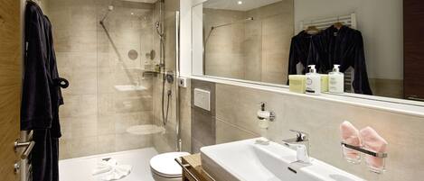 Un baño moderno con un lavamanos grande, una cabina de ducha de vidrio y un inodoro.