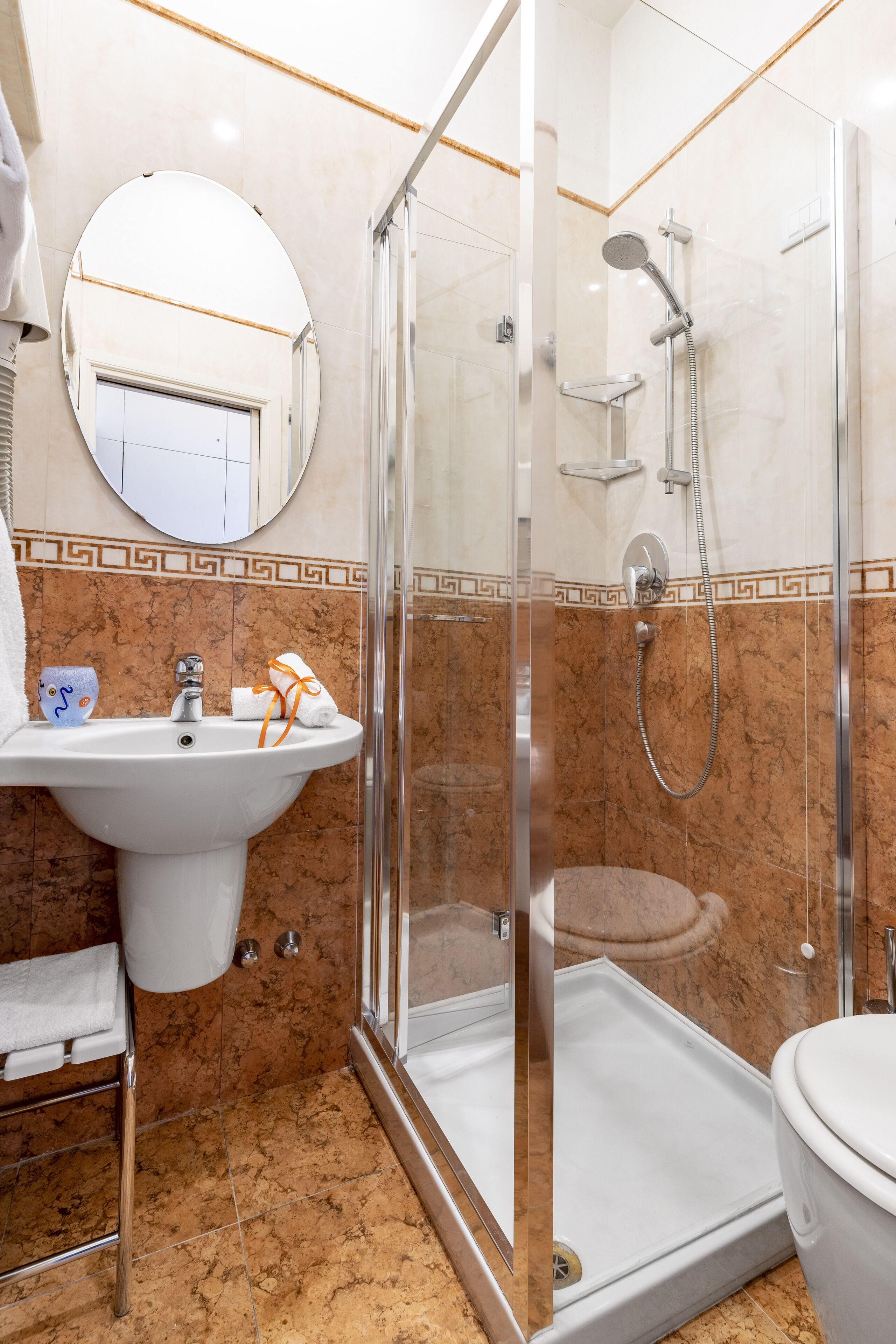 Une salle de bain avec une douche à parois de verre, un lavabo et des toilettes.