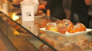 Eine Bäckereiauslage mit Gebäck und einer Kaffeetasse.