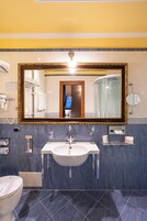 Un bagno con uno specchio grande, un lavandino e un water.