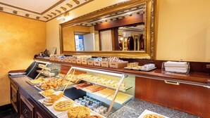 Un mostrador de buffet con diversas opciones de panadería y repostería.