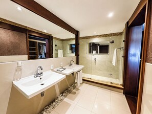 A modern bathroom with two sinks, a glass-enclosed shower, and a large mirror. - Sailing Hotel & Spa (Búzios)