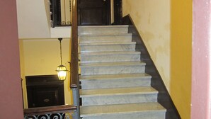 A staircase with marble steps and a black handrail, leading to a dark wooden door. - B & B Evergreen (Rome)