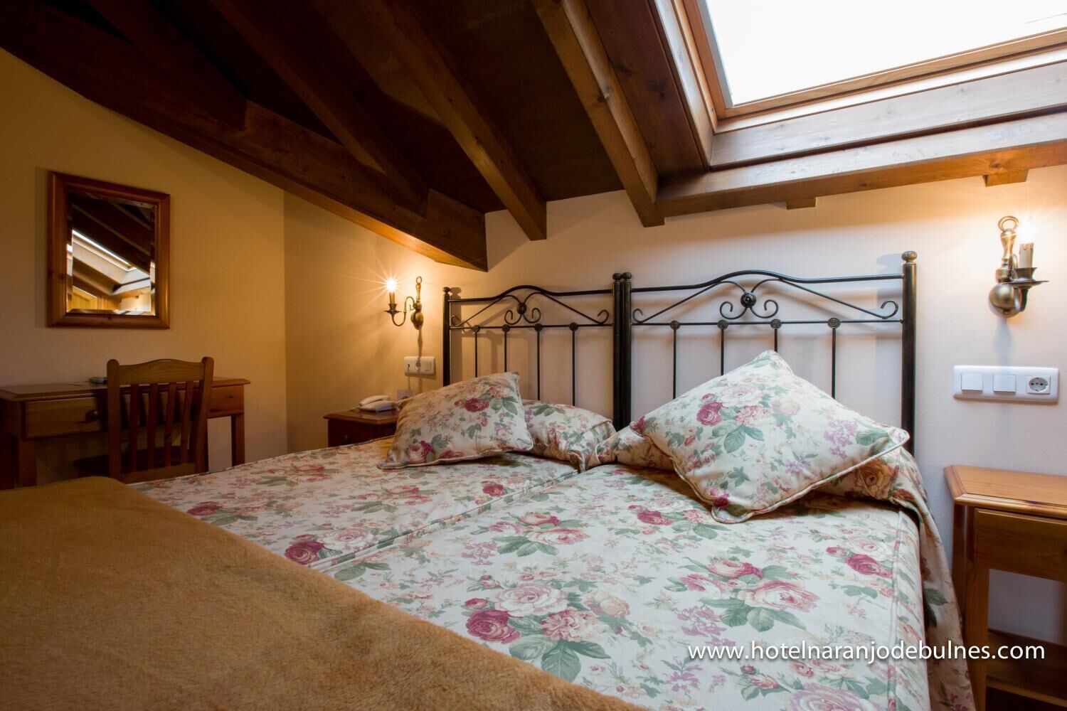 Une chambre à coucher avec un lit, un bureau, une chaise et un miroir.