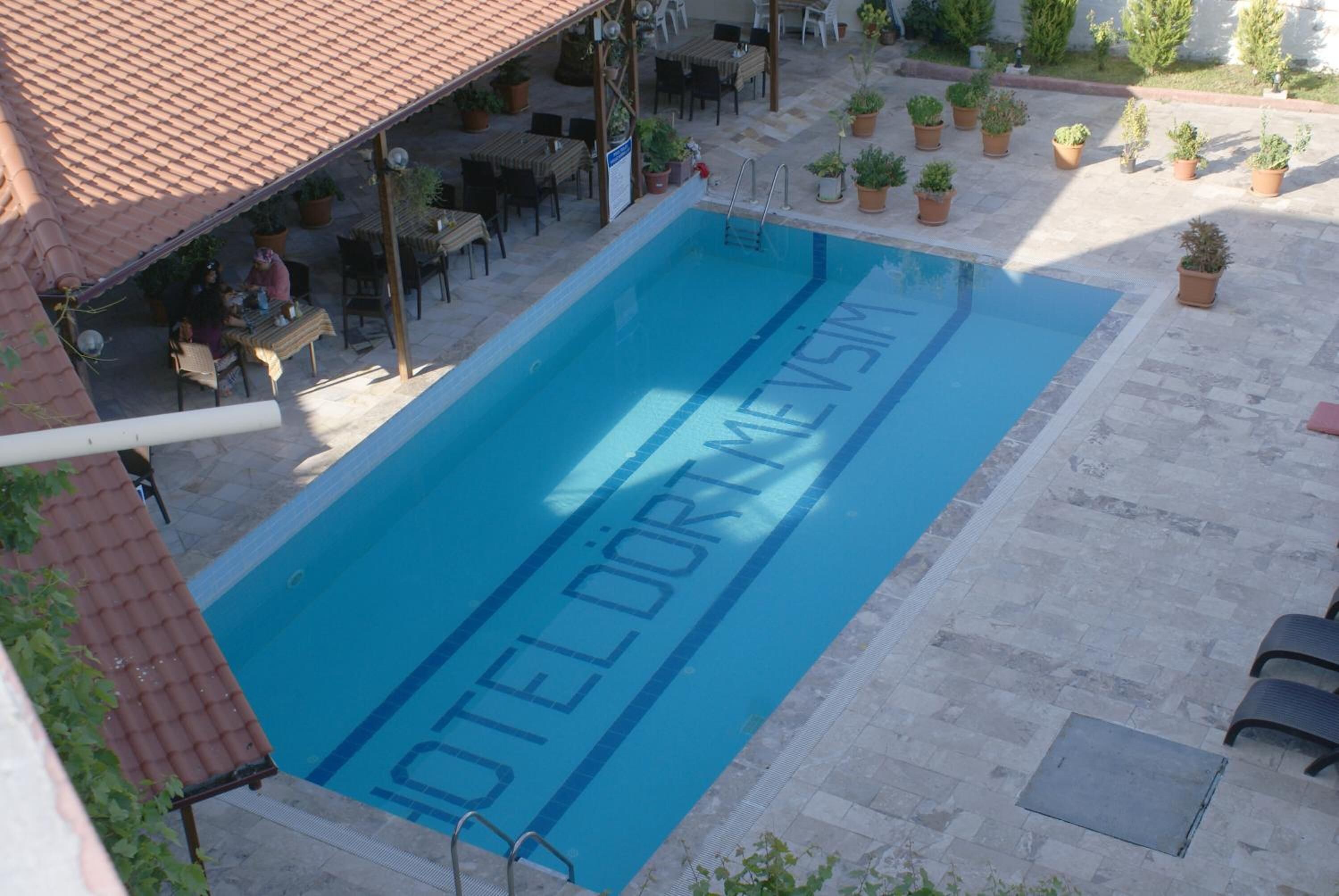 Une piscine dont la surface de l’eau est ornée de l’inscription « HÔTEL DORMERIM ».