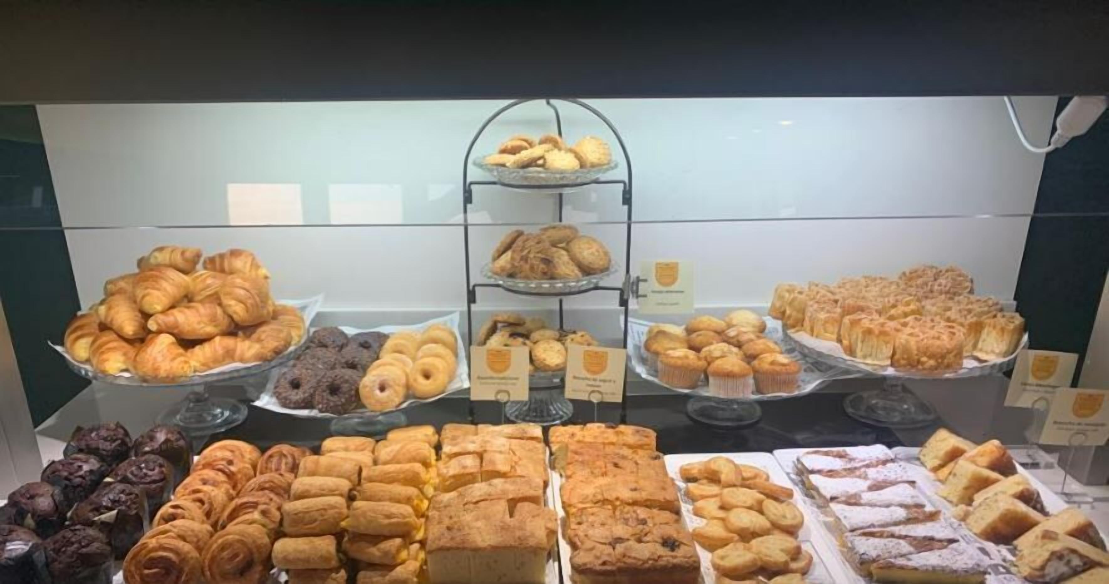 Una vitrina de panadería con diversos pasteles y productos de repostería.