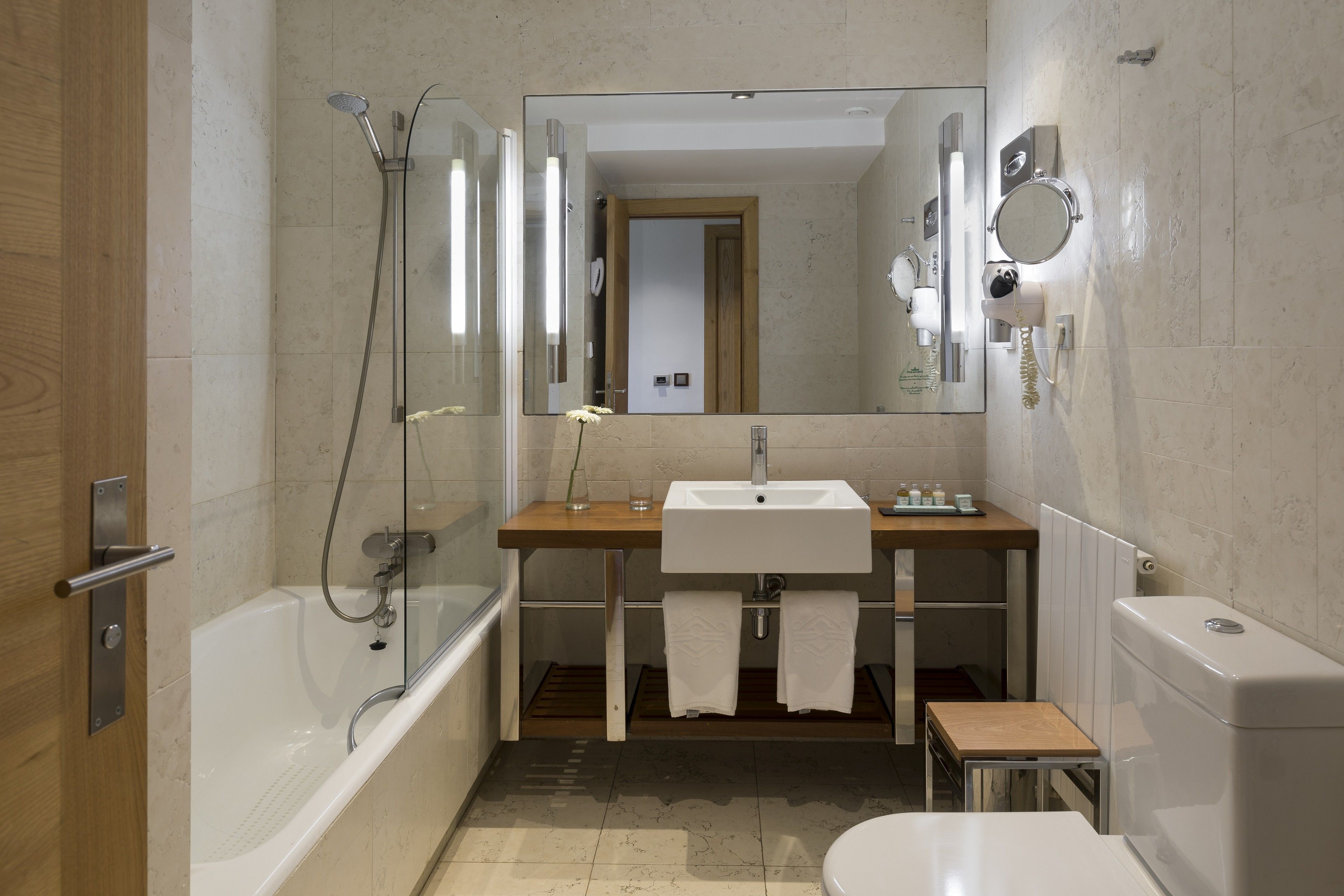 Un baño moderno con bañera, lavamanos, inodoro y ducha.