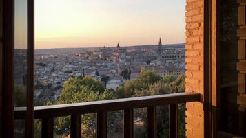 A balcony with a view of a cityscape during sunset.