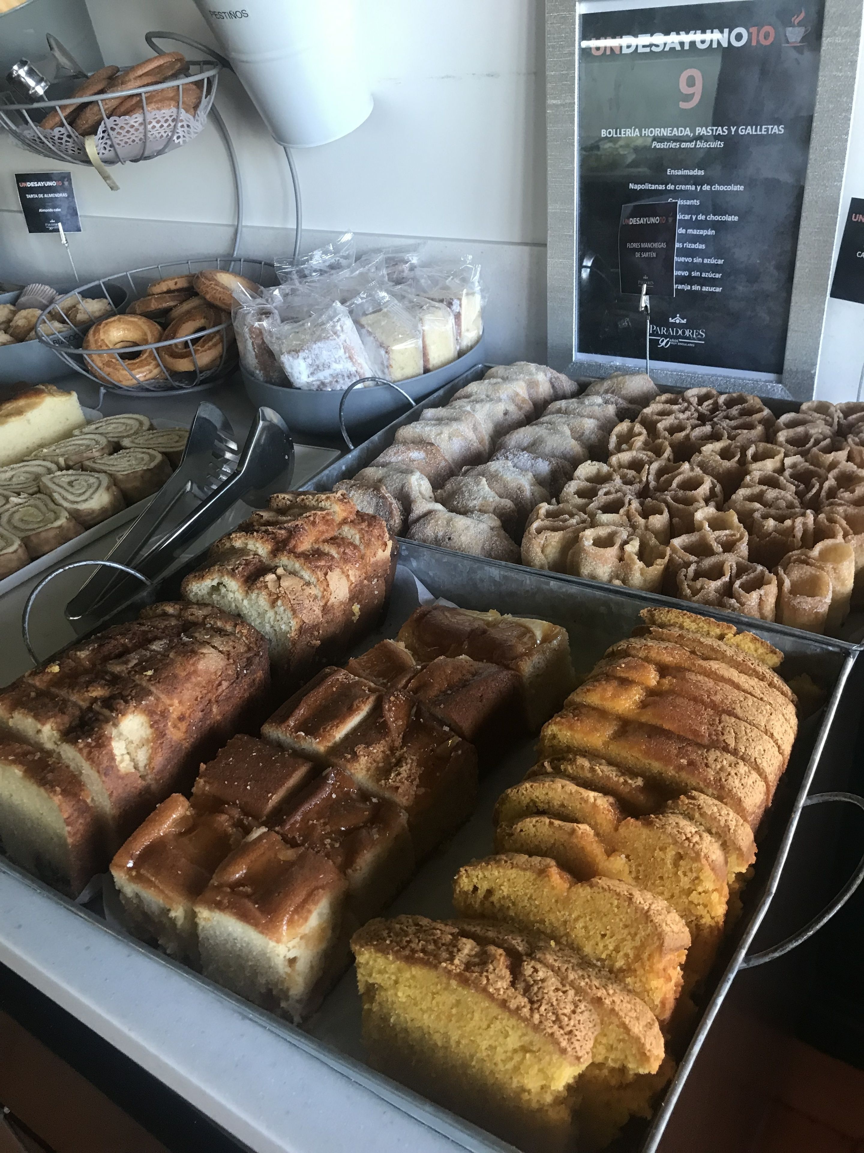 Een bakkerijdisplay met diverse gebakken producten, zoals brood, gebakjes en taarten.