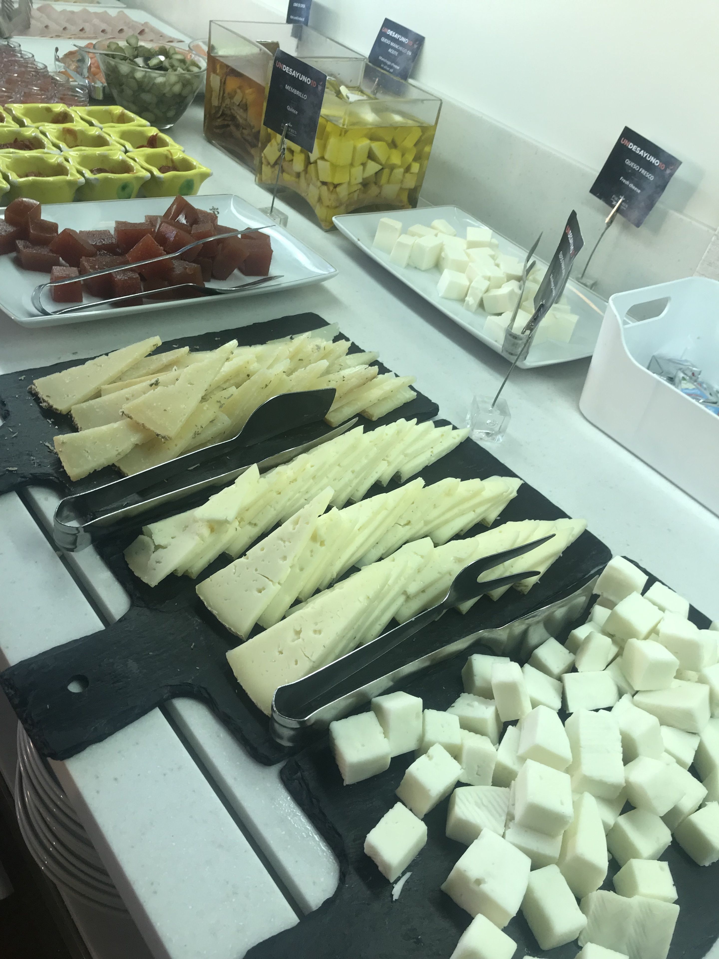 Buffet com diversas opções de queijos e frutas.