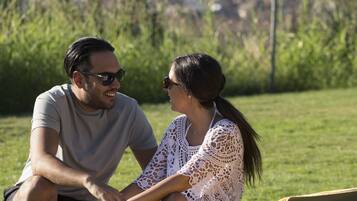 Una pareja sentada en un banco con un paisaje urbano al fondo.