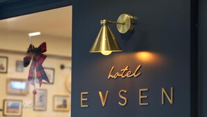 A hotel sign with the name 'EVSEN' and a decorative lamp.