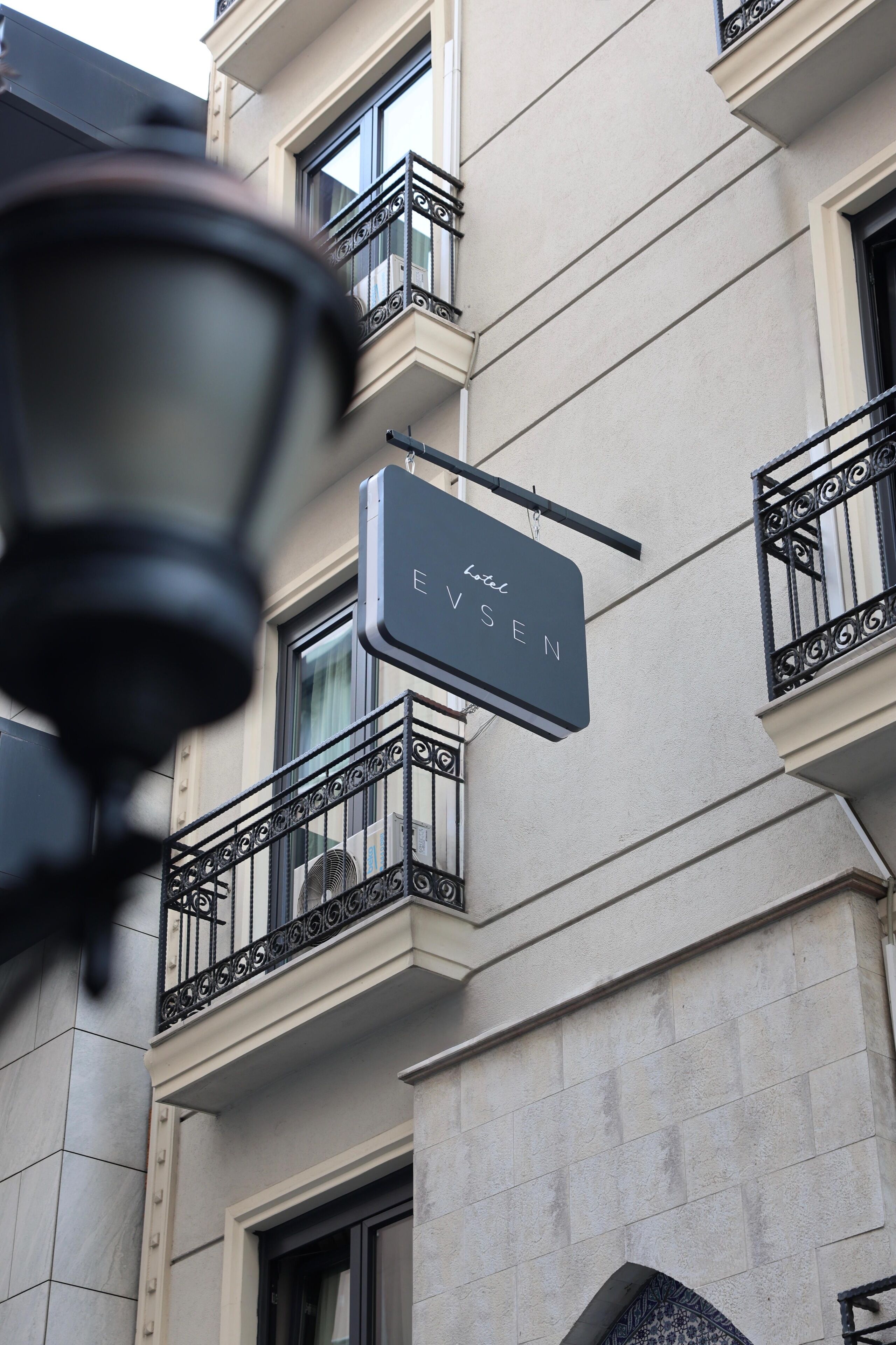 A hotel sign with the name 'Hotel Evensen' mounted on a building facade.