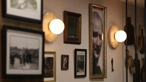 A room with a wooden panel wall, a bench, and framed pictures.