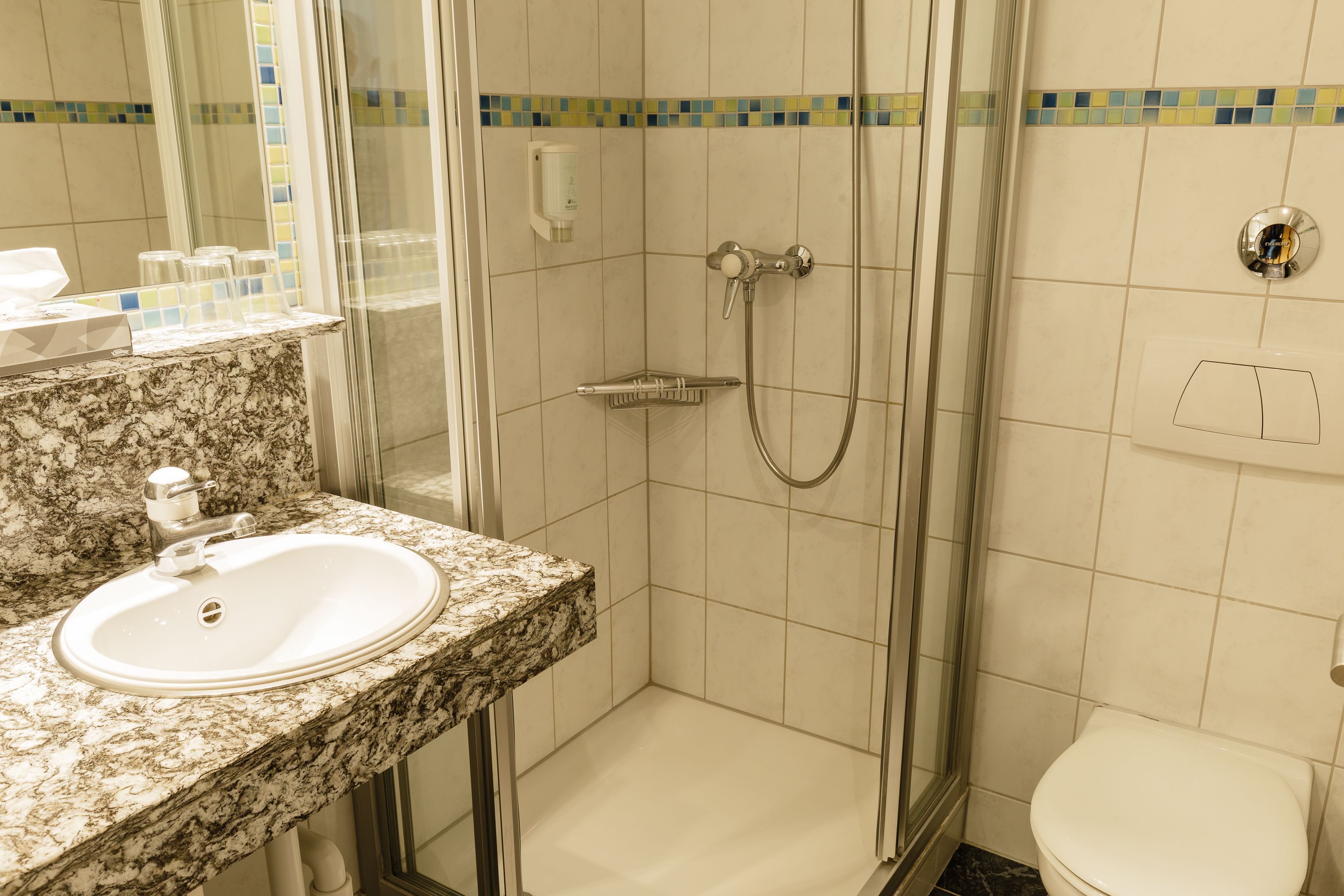 A bathroom with a sink, shower, and toilet.