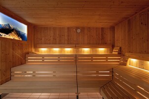 Una sauna de madera con bancos y vistas a montañas.