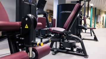 A gym with various exercise machines, including a leg press and a chest press.