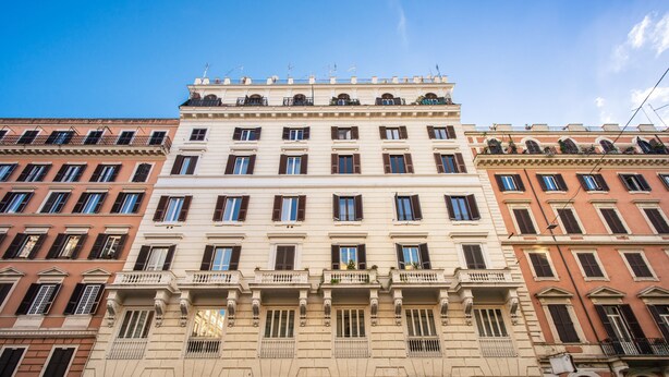 A multi-story building with a central entrance, storefronts on the ground floor, and balconies on the upper floors. - Auditorium Mecenate (Rome)