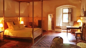 Une chambre à coucher de style traditionnel, avec un lit à baldaquin, un plafond en bois et une vue sur un couloir.