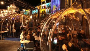 A restaurant with transparent dome structures, tables, and chairs, set in an urban environment with buildings in the background. - Hotel America (Locarno)