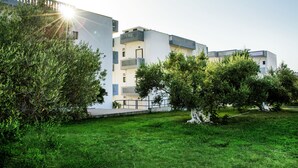 A modern building with balconies, surrounded by greenery and a well-maintained lawn. - Popi (Chania)