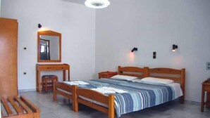 A bedroom with a wooden bed, a nightstand, a desk, a chair, and a mirror. - Popi (Chania)