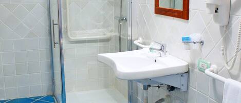 Un baño con cabina de ducha de vidrio, un lavabo y un inodoro.