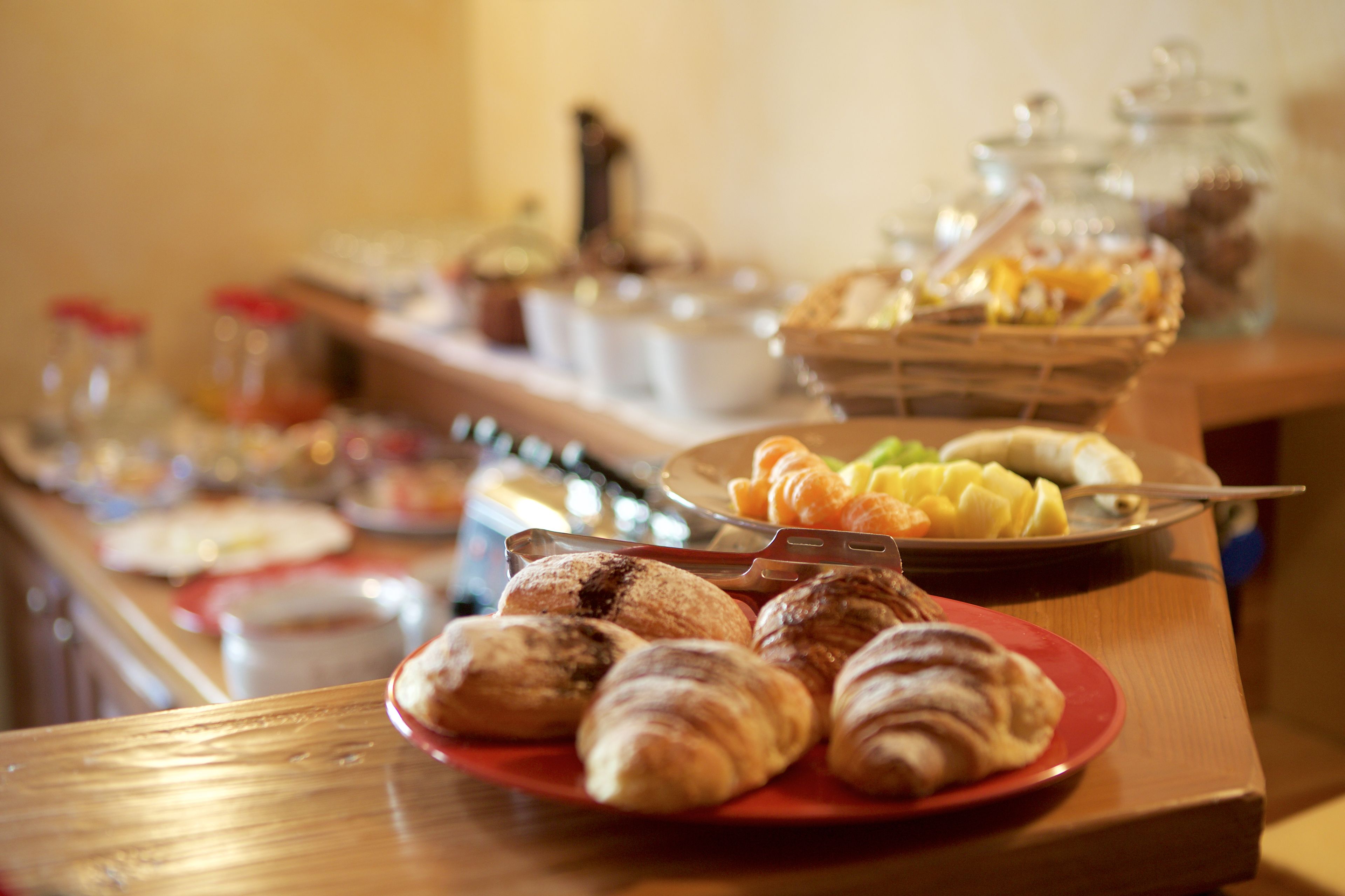 Ein reichhaltiges Buffet mit verschiedenen Speisen, darunter Gebäck und Obst.