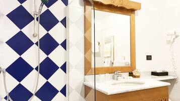 A bathroom with a shower, a sink, and a mirror.