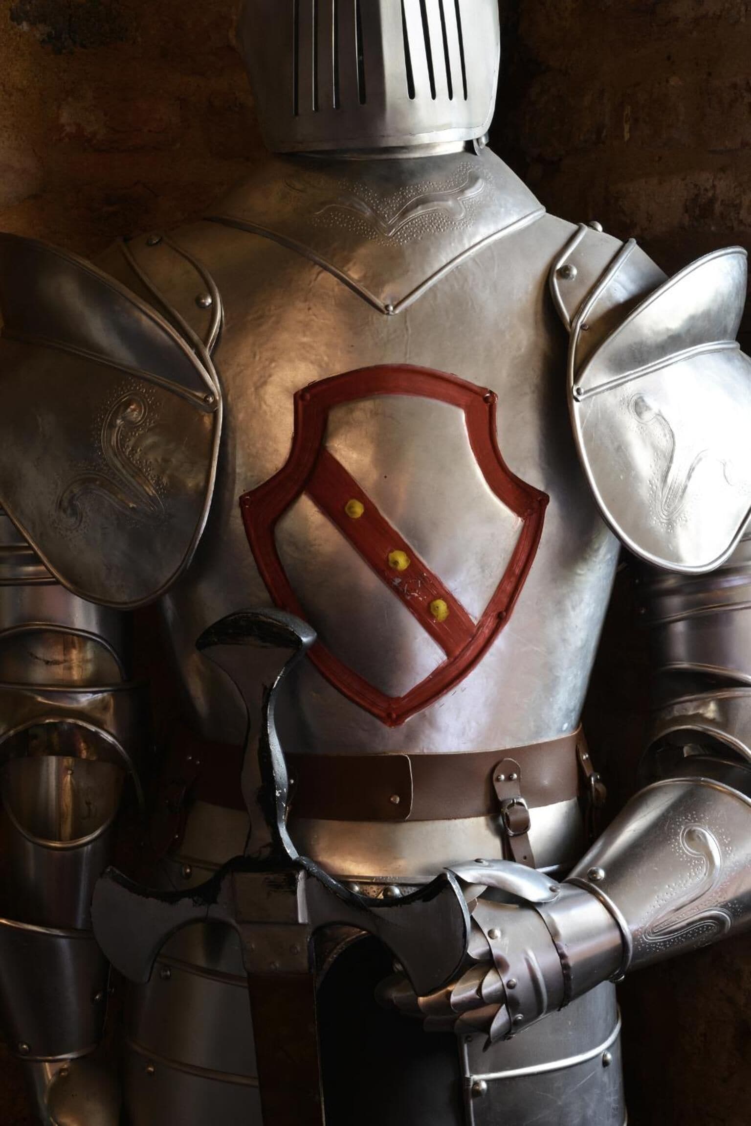 Armadura de caballero medieval con escudo con emblema.