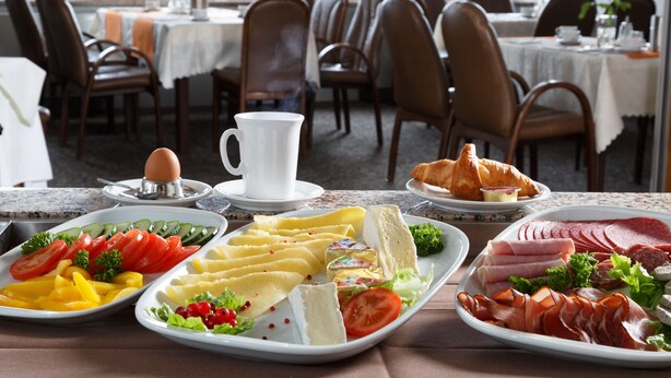 Ein reichhaltiges Frühstücksbuffet mit verschiedenen Speisen, darunter Eier, Käse, Fleischwaren und Gebäck.