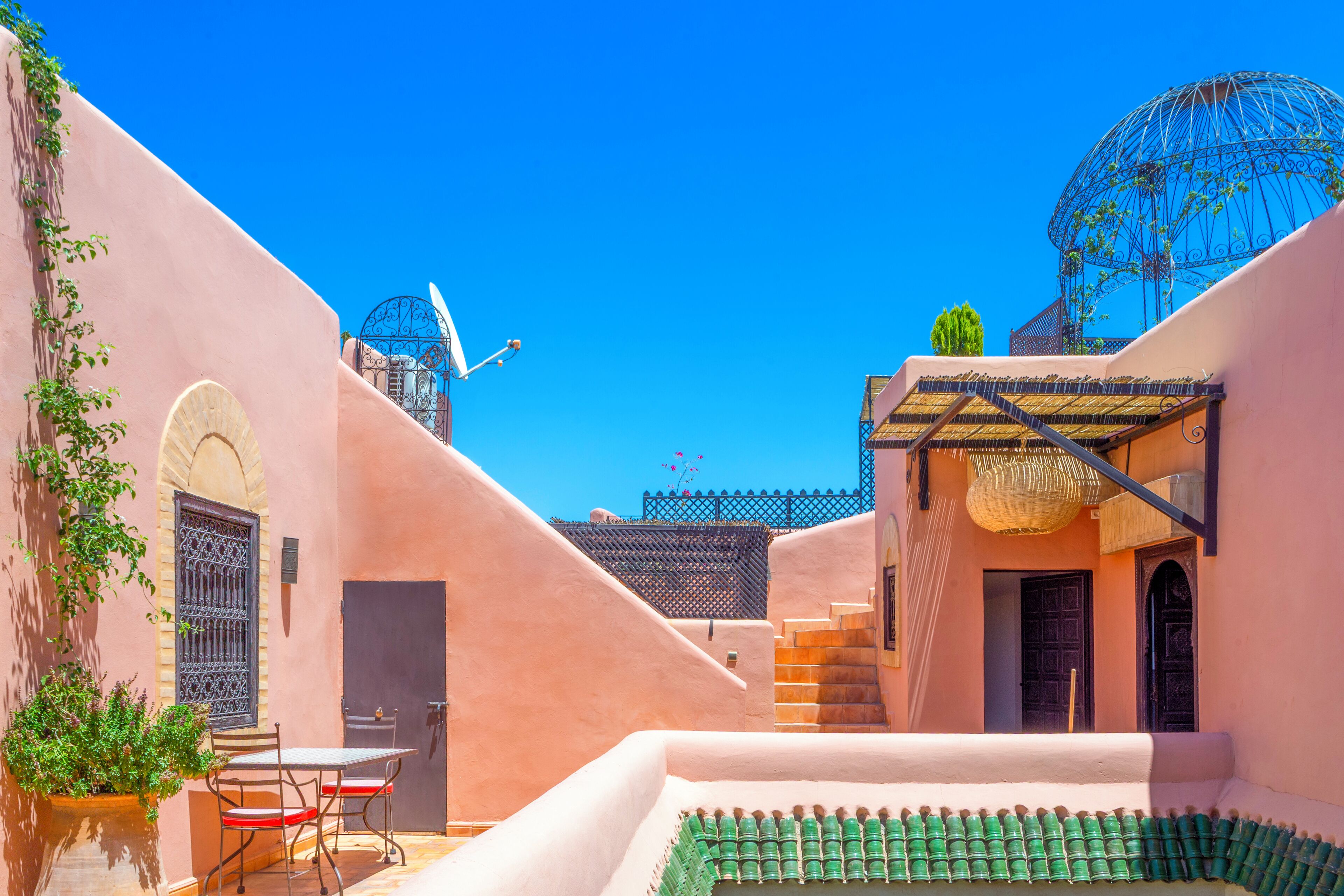 Un patio con una mesa, sillas, una escalera y una estructura en forma de cúpula.