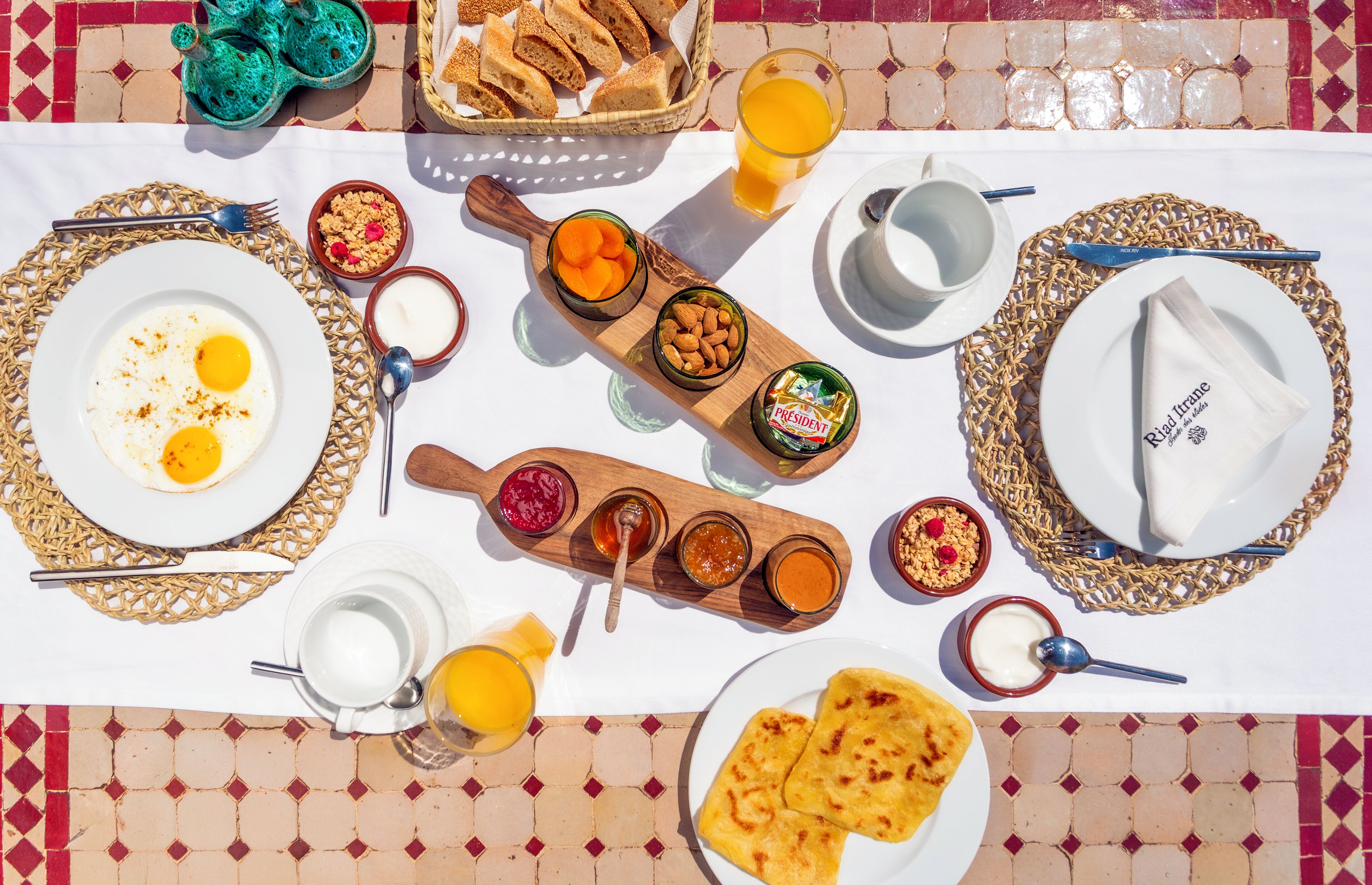 Une table de petit-déjeuner avec des œufs, des toasts, des fruits et divers condiments.