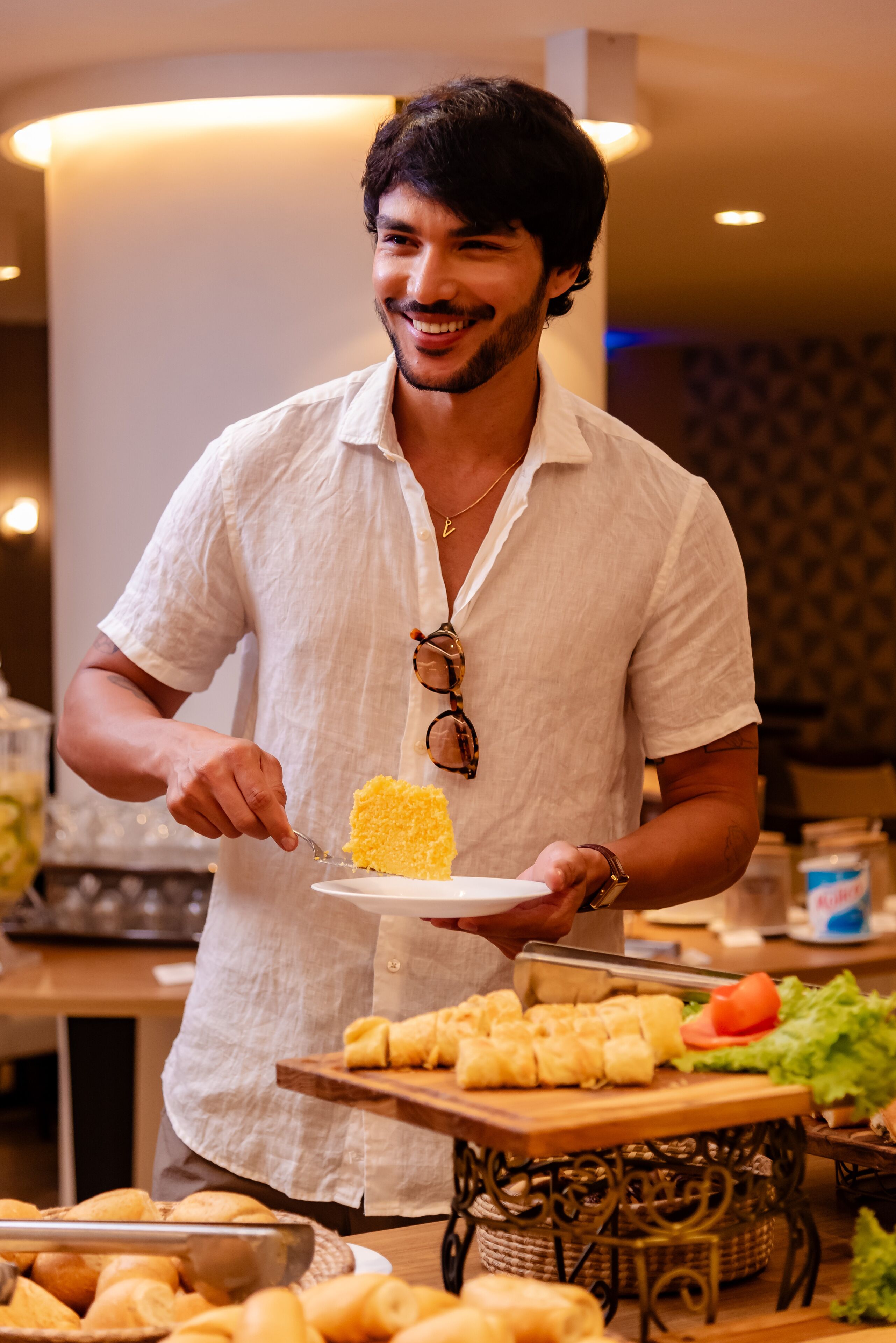 Une table de buffet proposant divers plats, notamment une assiette contenant un aliment jaune et un panier de petits pains.