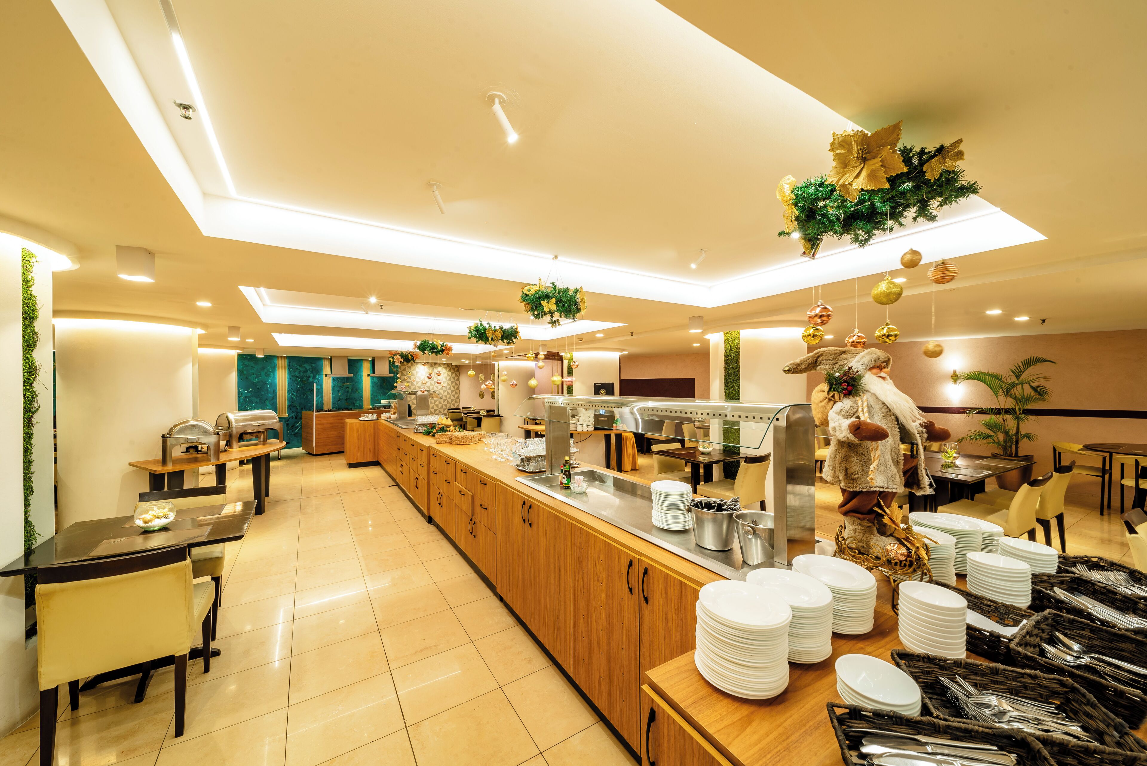 A modern hotel dining area with a long counter, multiple seating options, and a variety of amenities including a buffet setup.