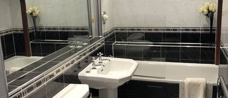 Un baño moderno con bañera, lavamanos e inodoro.