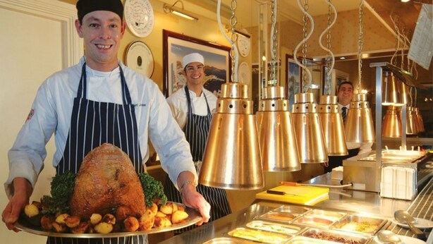 A buffet setup with various food items and a roasted chicken centerpiece. - Riviera Hotel (Torquay)