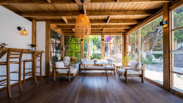 A wooden interior with a bench, chairs, and a hanging light fixture. - Costa Bodrum City (Bodrum)