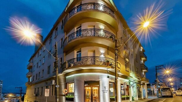 Un hotel de varios pisos con fachada curva, balcones y un letrero que dice "PALACE HOTEL".