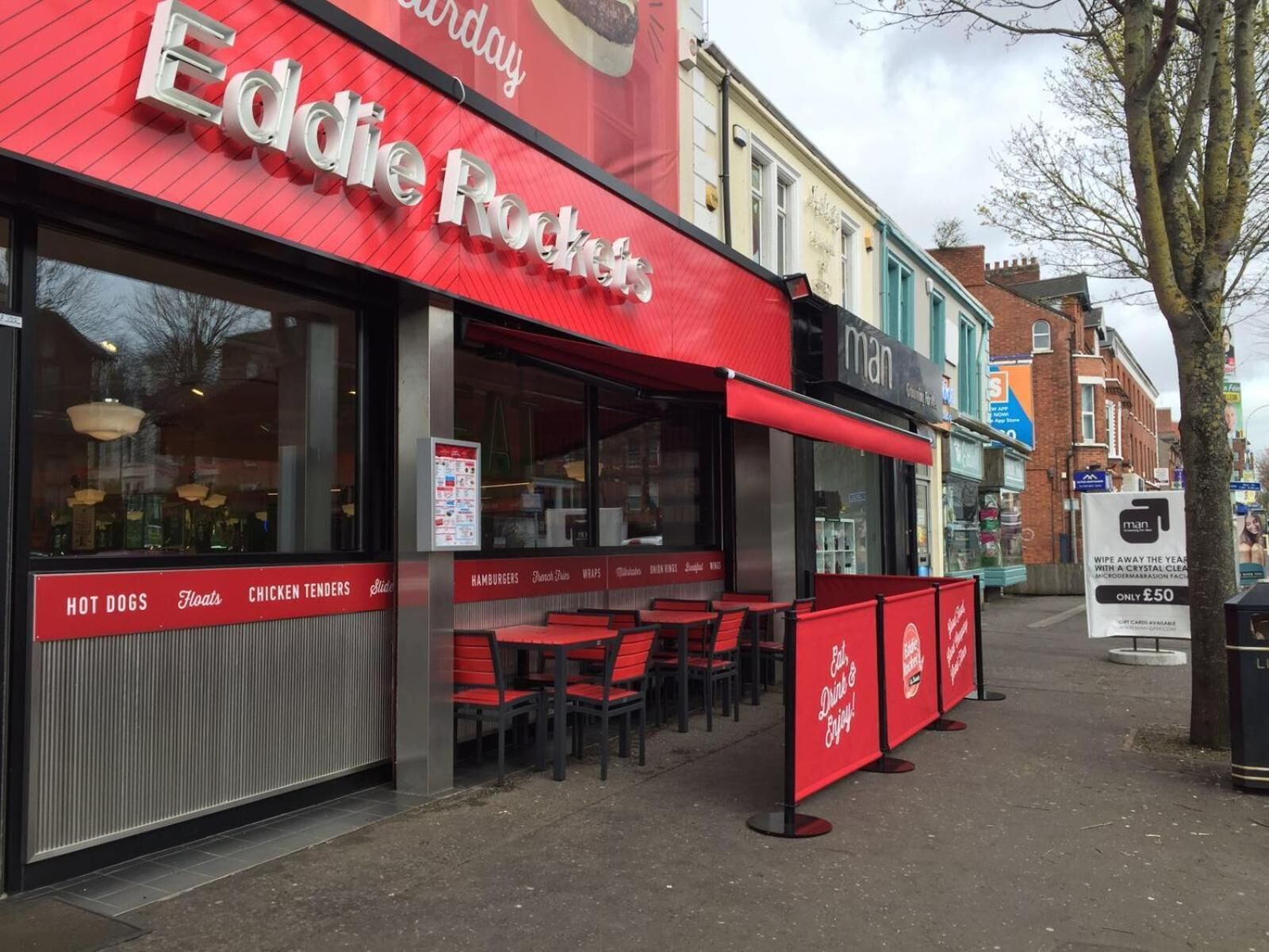 A restaurant named Eddie Rocco's with outdoor seating and a red awning.