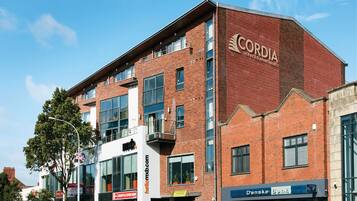 A multi-story building with a prominent 'CORDIA' sign, indicating it is a serviced apartment complex.