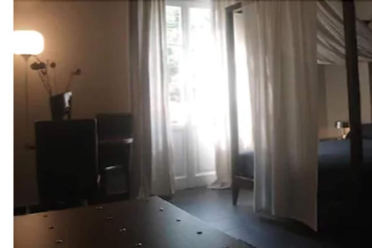 A hotel room with a bed, a desk, and a chair.