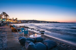 A beachside seating area with a table and chairs, overlooking the ocean. - Villa Sonia (Hersonissos)