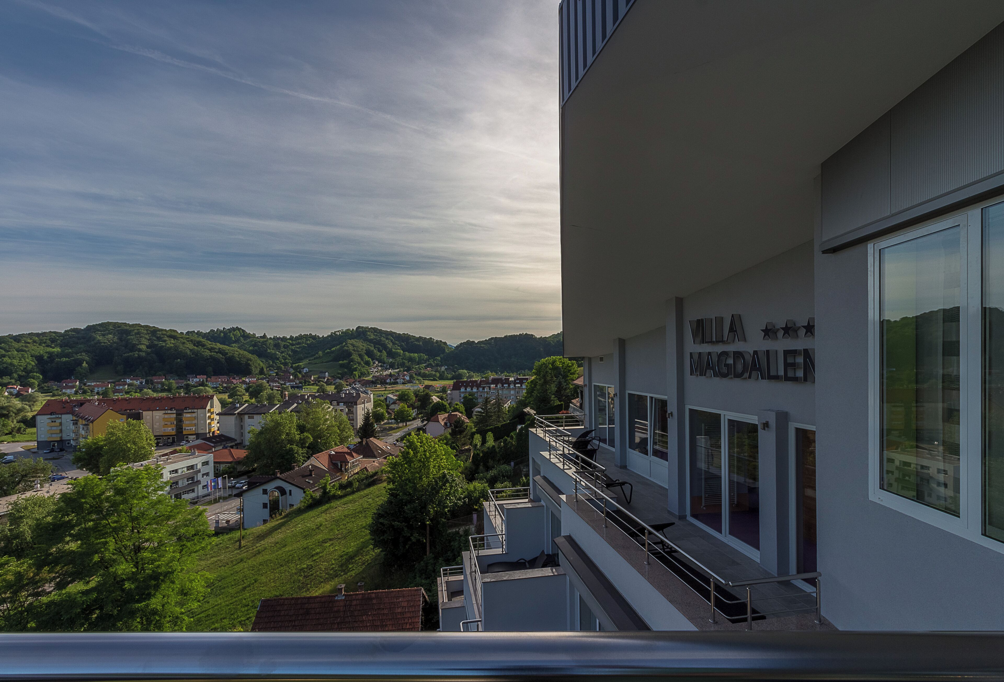 Un edificio moderno con un balcone che si affaccia su una cittadina. L'edificio presenta una insegna con la scritta 'Villa Magdalenen'.